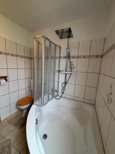 a white bath tub in a bathroom with a toilet at Hus Kalvsjö in Kalv