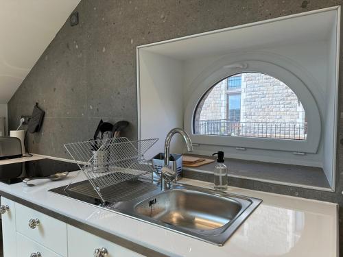 a kitchen with a sink and an arched window at Maison Fontanille in Le Puy-en-Velay