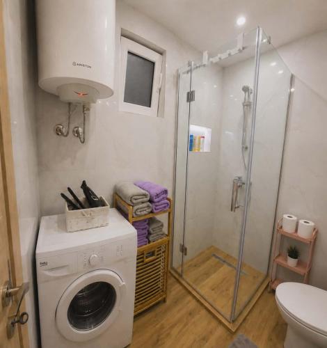 a bathroom with a washing machine and a shower at MM Central Apartment with Parking in Skopje