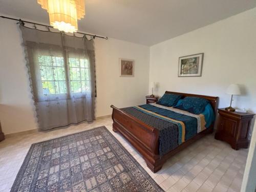 a bedroom with a bed and a window at La Maison Vieille in Peillon