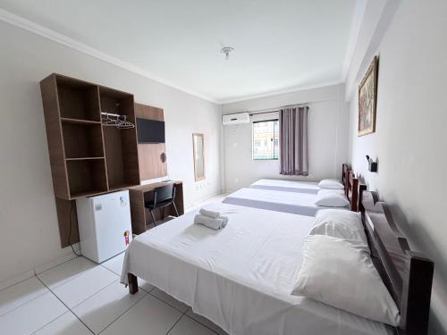 a bedroom with two beds and a small kitchen at Palace Hotel Pôr do Sol in Vitória da Conquista