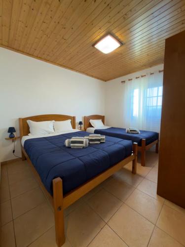 a bedroom with two beds with blue sheets at Retiro dos Cabritos in São Mateus