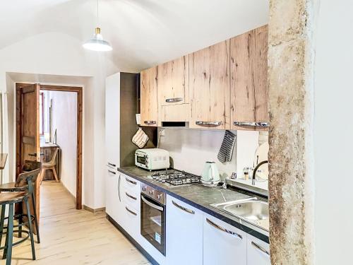 a kitchen with white appliances and wooden cabinets at Apartment Novecento by Interhome in Monterotondo