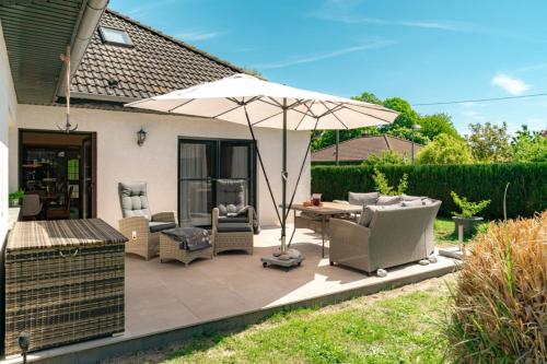 a patio with a table and an umbrella at Ferienhaus Sonneneck in Kluis