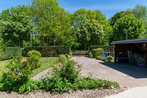a garden with a pavilion and bushes and trees at Ferienhaus Sonneneck in Kluis