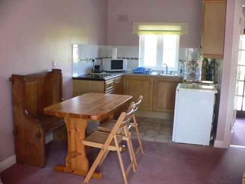a kitchen with a wooden table and a refrigerator at Bleantis Mountain Cottage in the Comeragh Mountains in Dungarvan