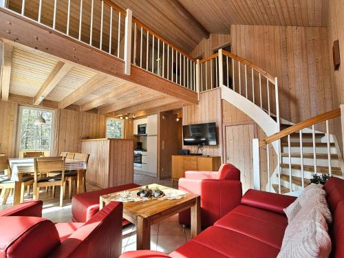 a living room with red furniture and a staircase at Seebrise Baabe in Baabe