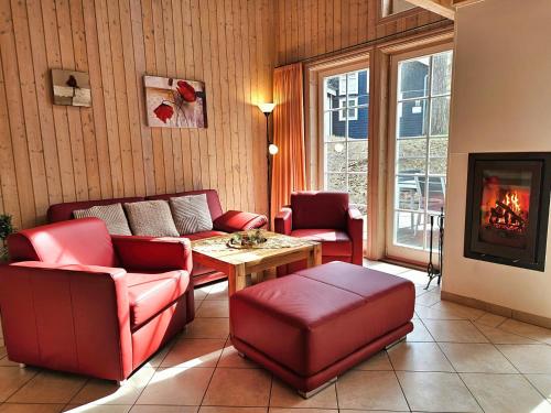 a living room with red furniture and a fireplace at Seebrise Baabe in Baabe