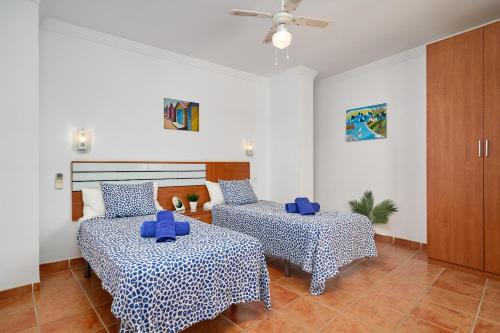 a room with two beds and a table and chairs at Apartamentos Nerjaluna in Nerja