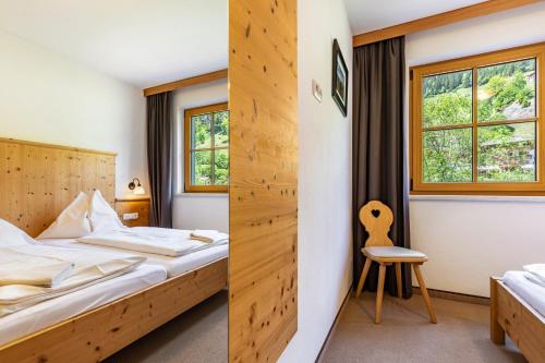 a hotel room with a bed and a chair at Appartements Stockinger A1 in Grossarl