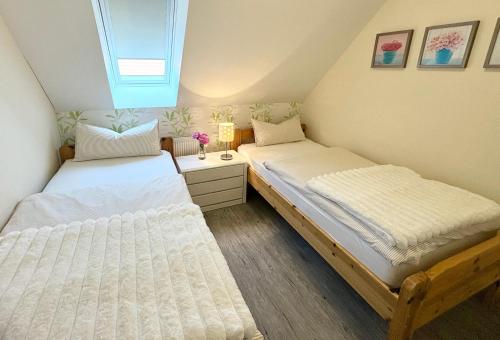 two beds in a small room with a window at Alte Schule Breese in Dannenberg