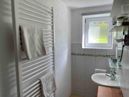 a white bathroom with a sink and a window at Moderne Ruheoase Allgäu in Oberreute