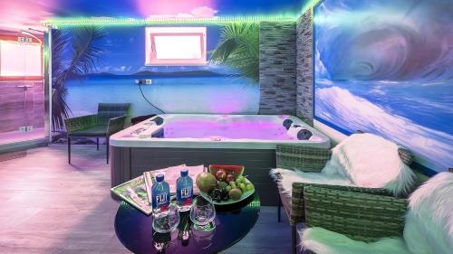 a room with a tub with a table with a bowl of fruit at Apartment Seeterrasse in Schalkenmehren