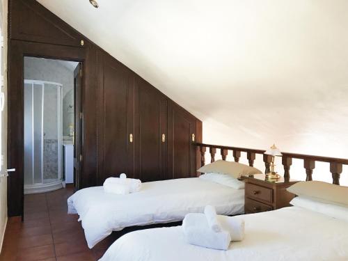 a bedroom with two beds with white sheets at Nueva Villa Ignacia in Arriate