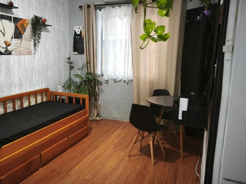 a bedroom with a bed and a table with chairs at Cantinho da Jessi in São Vicente