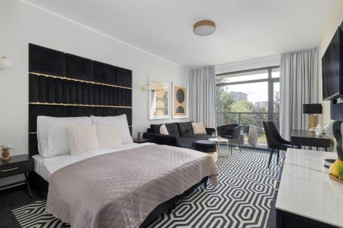 a bedroom with a bed and a living room at Solny Resort Apartament A245 in Kołobrzeg