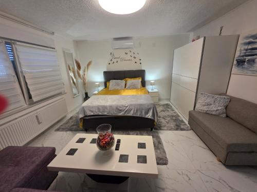 a bedroom with a bed and a couch and a table at ENA 1&2 apartments-free parking 2200 m2-truck,trailer,boats friendly-EASY D1 access in Karlovac