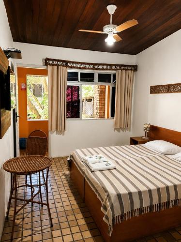a bedroom with a bed and a chair and a window at Hotel Pousada Casuarinas in Recife