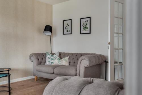 a living room with a couch and a lamp at Recently Refurbished House Sleeps 5 near Stadiums in Liverpool
