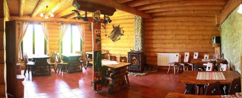 un comedor con mesas y sillas en una cabaña en Zrub Benango en Mengusovce