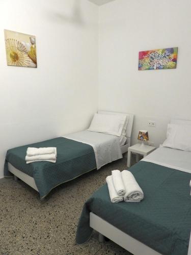 a bedroom with two beds with towels on them at Doribella Holiday House in Pollina