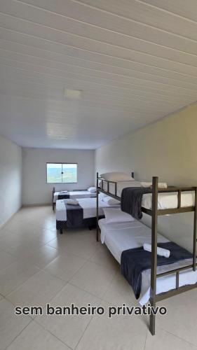a room with three bunk beds and a window at Pousada Serra do Sol in Mariana
