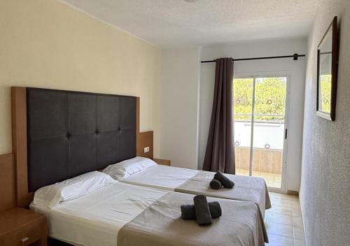 a bedroom with a large bed with two slippers on it at El Cortijo Escana in Es Cana