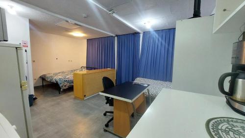 a room with a room with a bed and a desk at Cozy studio apartment with 2 beds and kitchen in Audun-le-Tiche