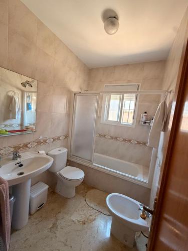 a bathroom with a toilet and a sink and a shower at Chalet Matalascañas in Matalascañas