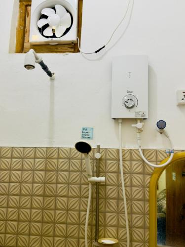 a bathroom with a shower and a fan and lights at Stay Home Arugambay in Arugam Bay