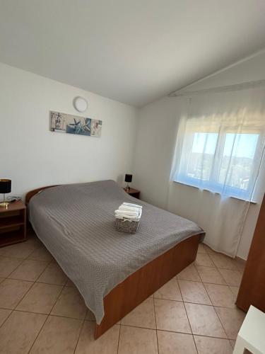 a bedroom with a bed and a window at Apartments Duda in Vir