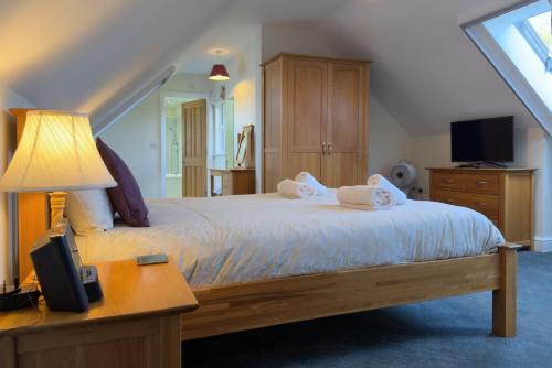 a bedroom with a bed with two towels on it at Walled garden cottage in Hassocks