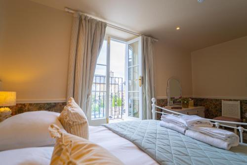 a bedroom with a bed and a large window at The Market Tavern in Bampton
