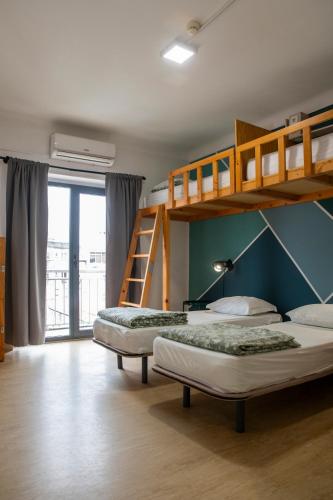 a bedroom with two bunk beds and a ladder at WOT Nomad Social in Lisbon