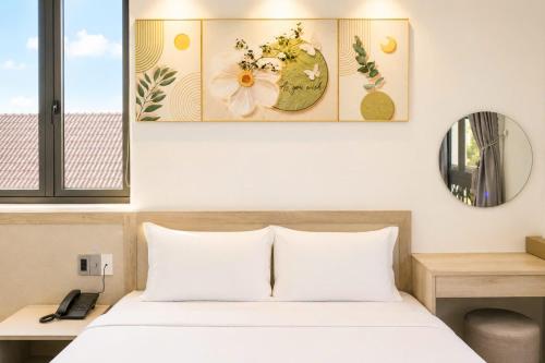 a bedroom with a bed with white sheets and flowers on the wall at Khách sạn New Star 2 in Thiện Ngôn