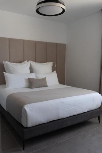 a large bed with white sheets and pillows at Costa Adeje Garden Aparthotel in Adeje