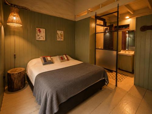 a bedroom with a large bed and a kitchen at A la Gurda Hostel - Barrio Sur in San Miguel de Tucumán