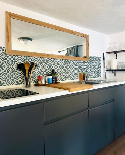a kitchen counter with a sink and a mirror at El nido de aguila in Casares