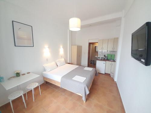 a bedroom with a bed and a table and a tv at Lydia Mare in Agios Kirykos