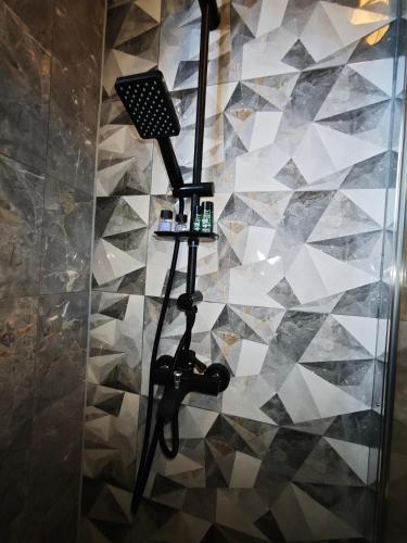 a shower in a bathroom with a tiled wall at Μπαλκόνι με Θέα in Pérdika
