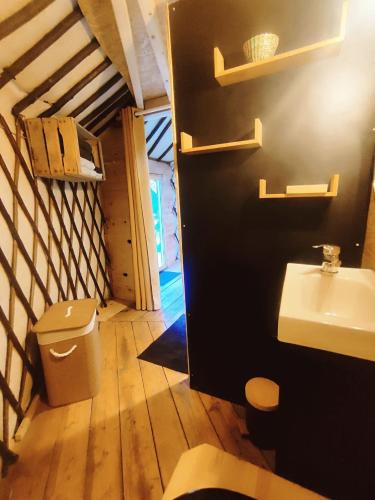 a bathroom with a sink and a toilet in a room at Au Clères de yourte in Cléres