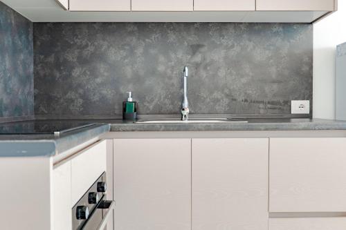 a kitchen with white cabinets and a sink at SeaScape Residence in Borsh