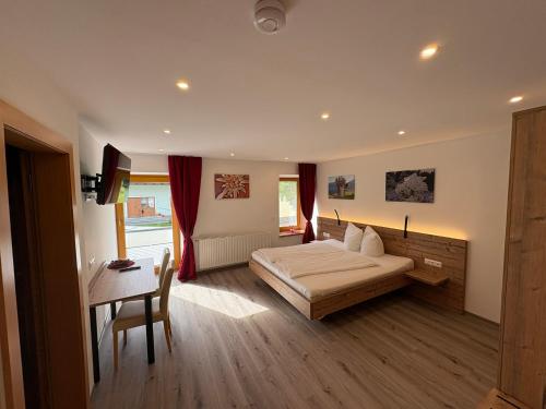 a bedroom with a bed and a table and a desk at Frühstücks-Radpension Taurer-Thoman in Dellach im Drautal