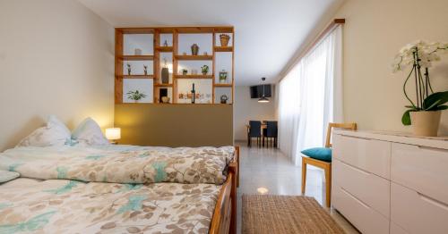 a bedroom with a bed with a dresser and a window at Studio Arve Visperterminen in Visperterminen