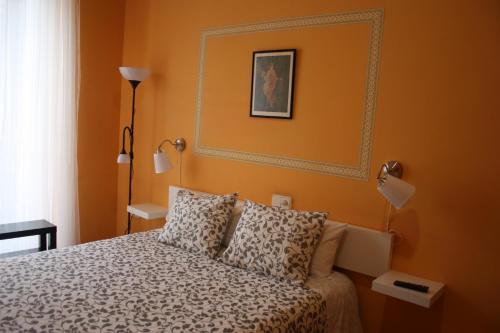a bedroom with a bed with orange walls at B&B "Domus Atilia" in Sagunto