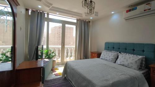 a bedroom with a bed and a large window at 378 Pyramids apartment in Nazlet el-Sîsi