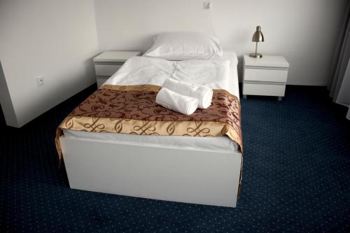 a bedroom with a bed with two towels on it at Złoty Łan in Nowa Sól
