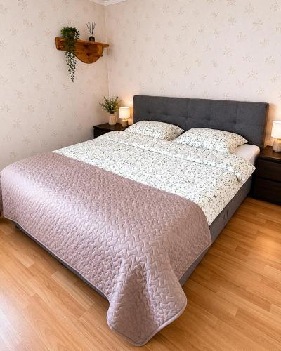 a large bed in a bedroom with two lamps at Spacious apartment with balcony in Tallinn