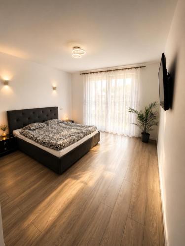 a bedroom with a large bed and a wooden floor at Casa Mediteraneana Verde in Alba Iulia