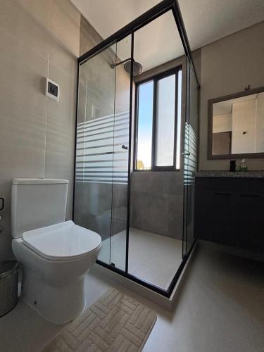 a bathroom with a toilet and a glass shower at Aura Exclusive - Achumani in La Paz